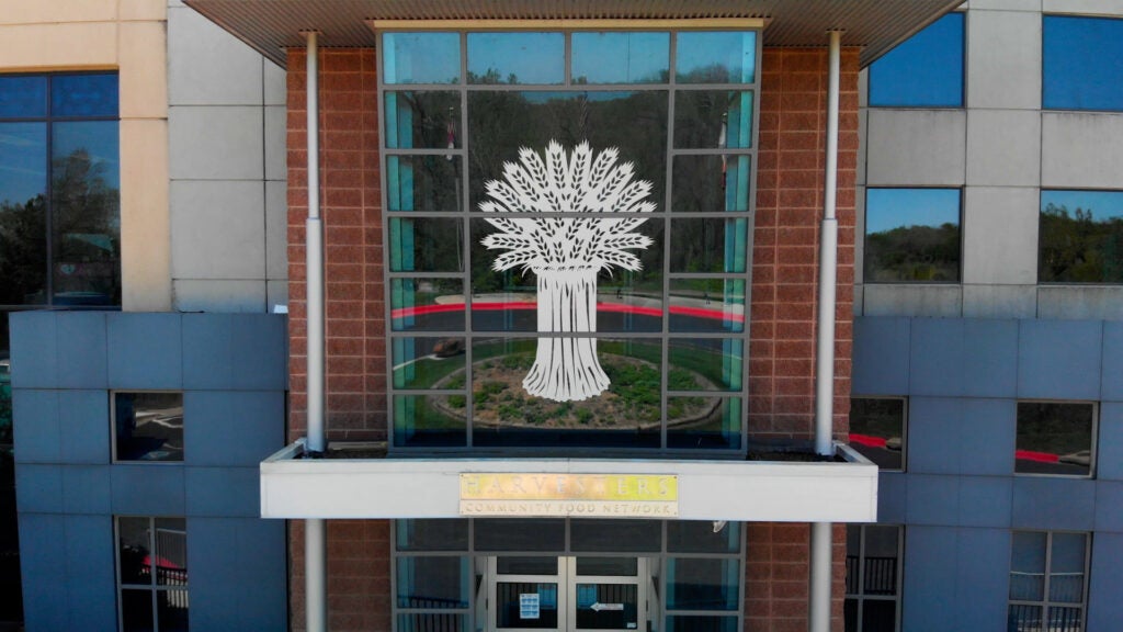 Exterior of Harvesters Community Food Network building. A large wheat sheaf image is on the glass facade.