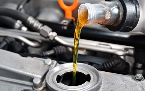 Certified technician performing an oil change at a Cable Dahmer service center