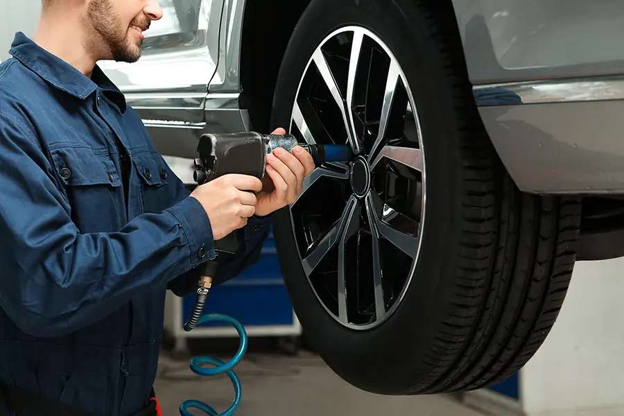 Technician balancing a wheel and tire assembly in the service bay